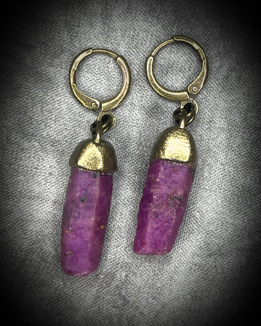 Raw ruby crystal earrings in gold finish on hypoallergenic brass huggie hooks, July birthstone gemstone jewelry handmade in Baltimore Maryland. Closeup.