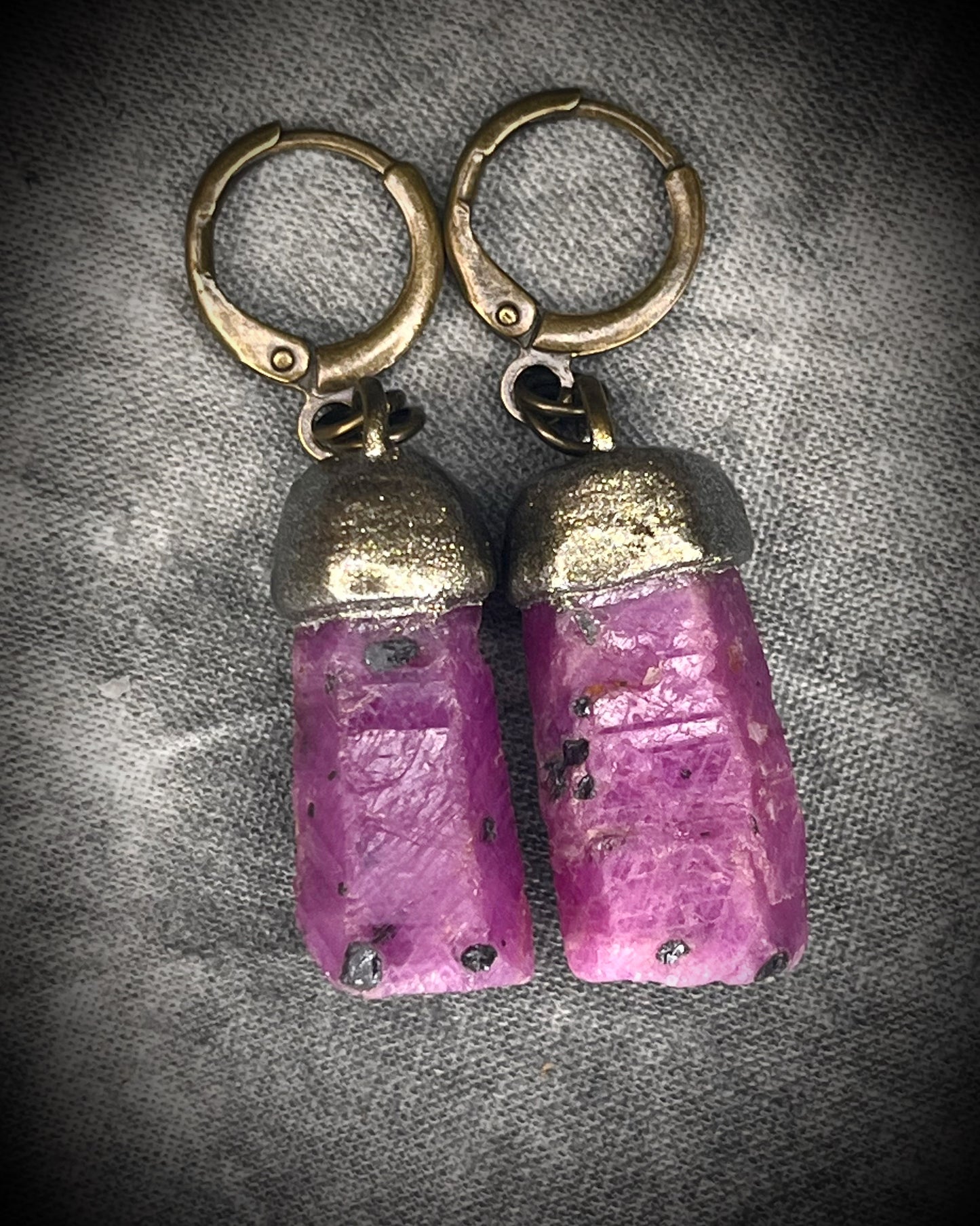 Raw ruby crystal earrings in gold finish on hypoallergenic brass huggie hooks, July birthstone gemstone jewelry handmade in Baltimore Maryland. Closeup.