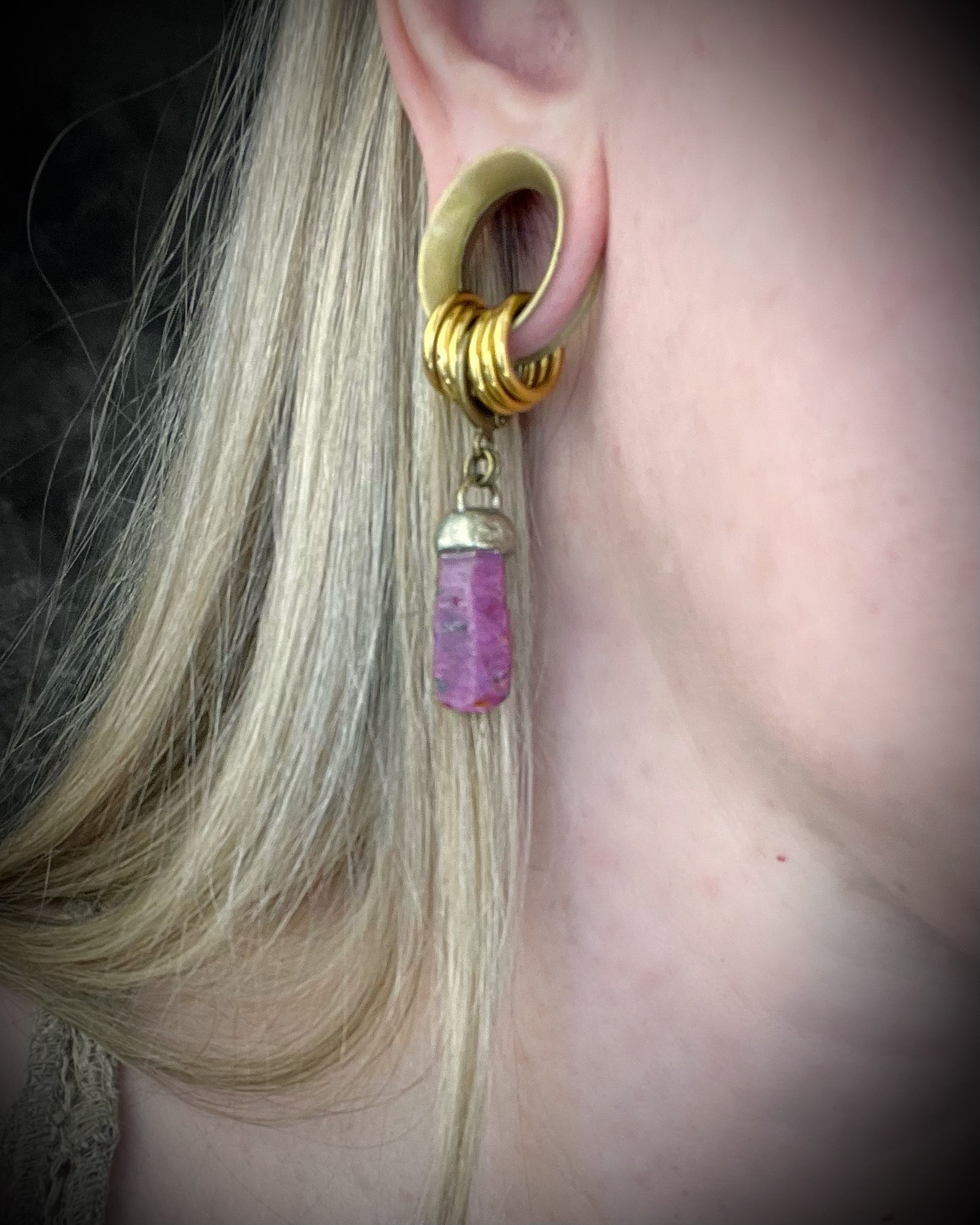 Raw ruby crystal earrings in gold finish on hypoallergenic brass huggie hooks, July birthstone gemstone jewelry handmade in Baltimore Maryland. Worn here.