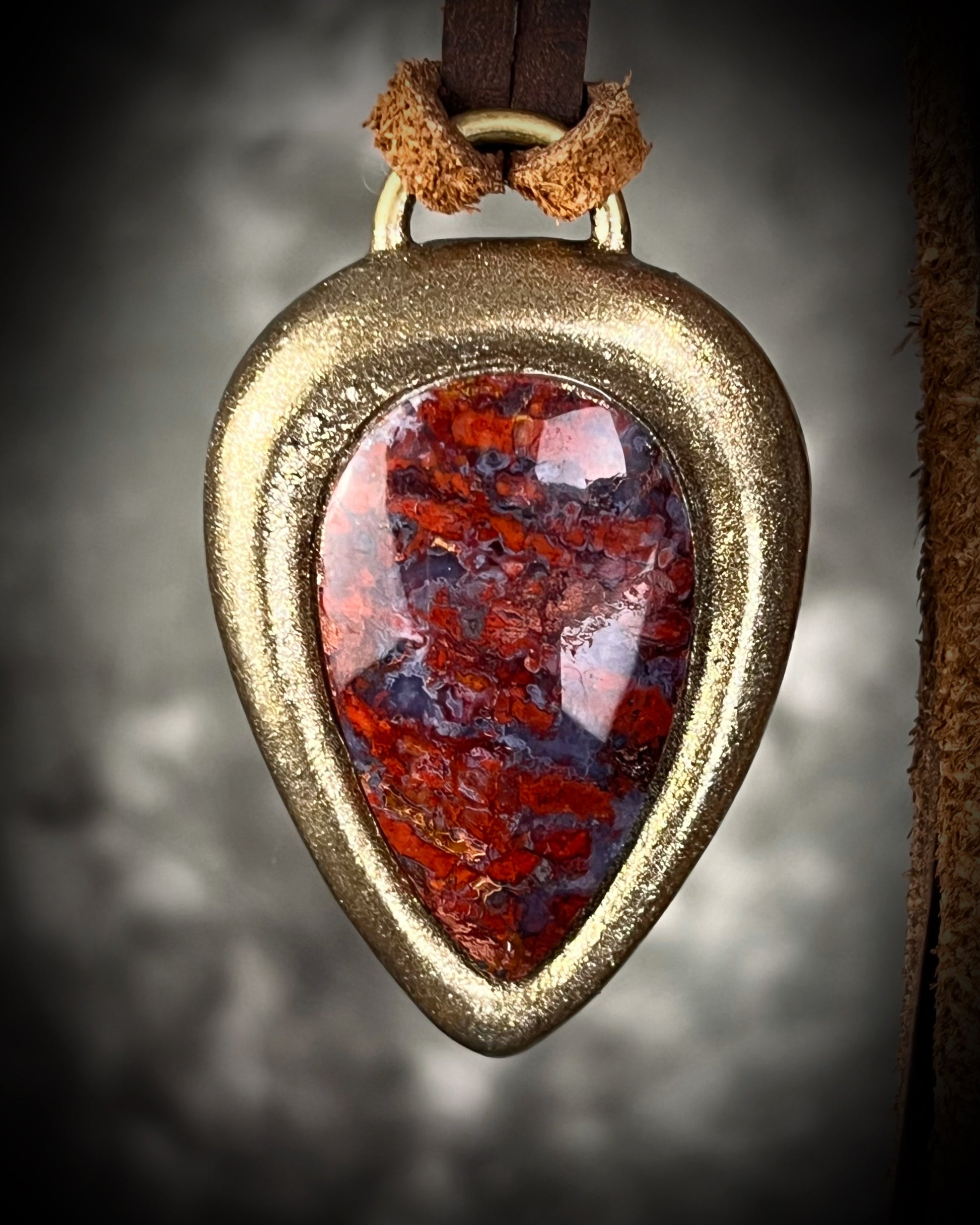 Red moss agate pendant in a gold finish, handmade and hung from brown earthy leather. Grounding and manifestation talisman for 2026 year of the fire horse. 