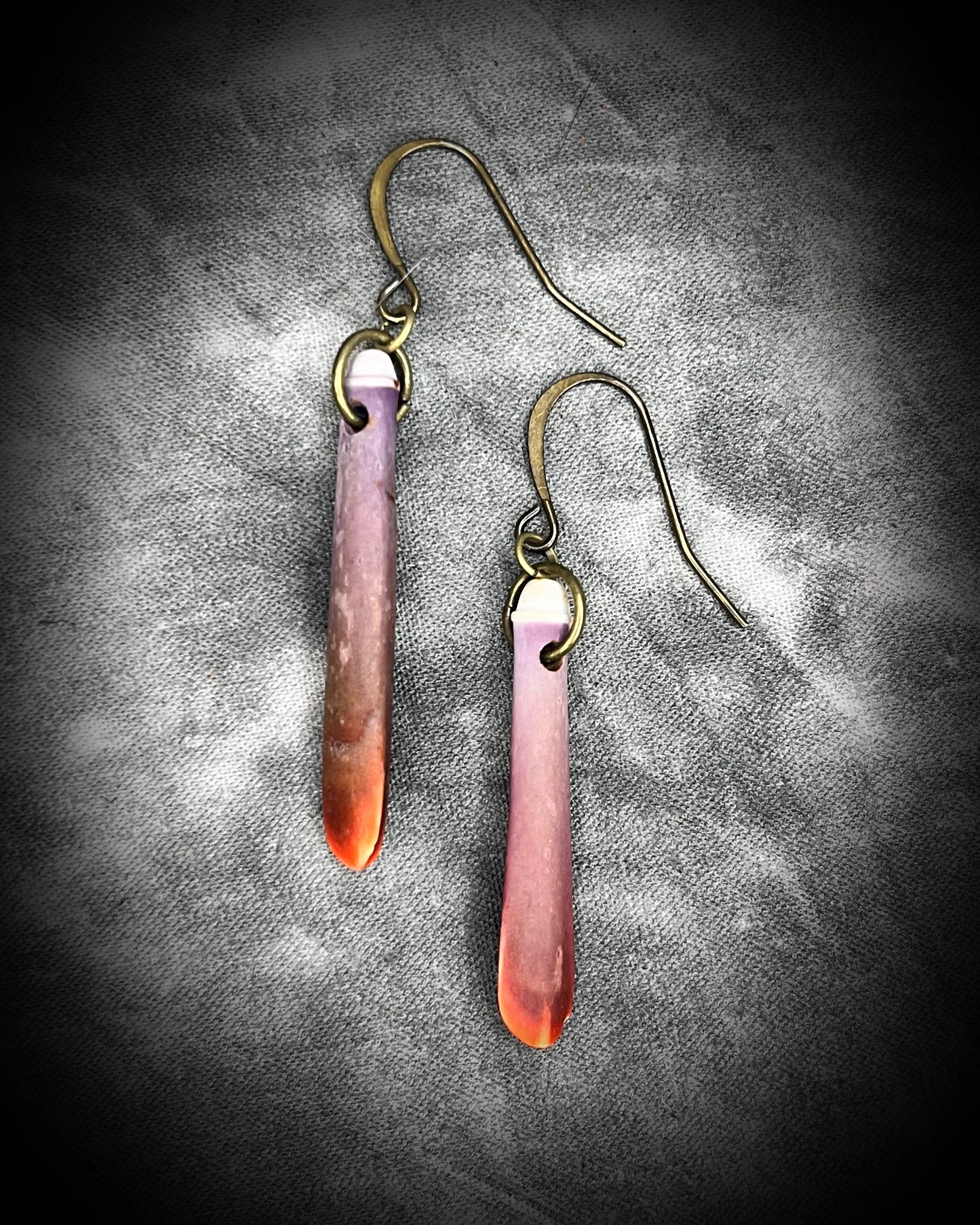 Reddish-purple sea urchin spine earrings on hypoallergenic brass hooks — bohemian ocean inspired statement jewelry.