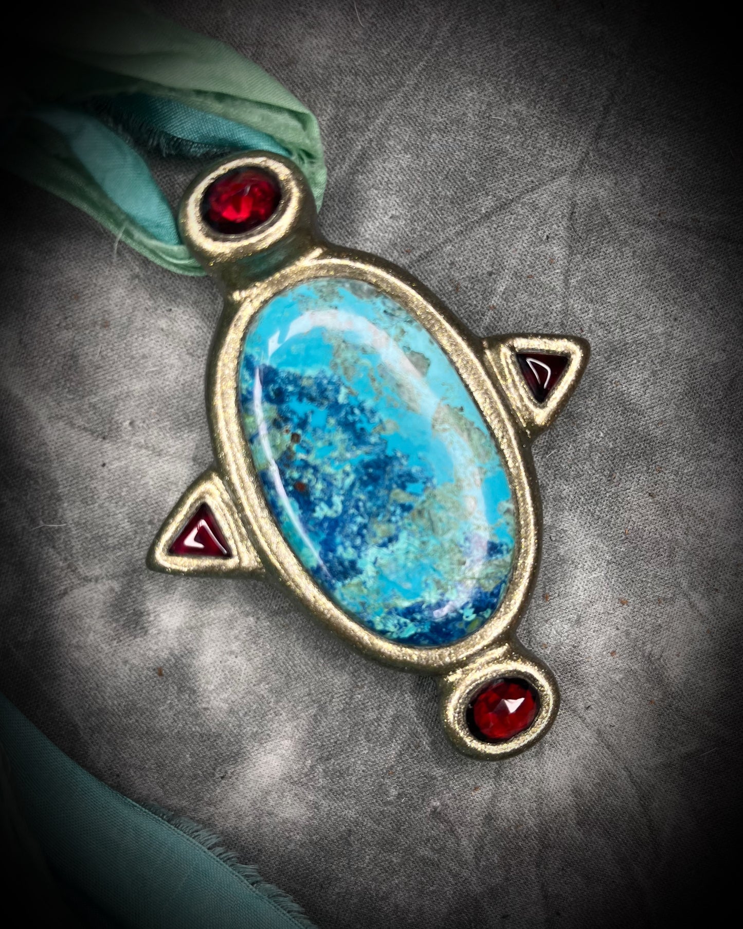 Regal handmade chrysocolla pendant adorned with 4 sparkling garnets in the cardinal directions. The Empress Talisman, gold finish artisanal pendant on soft aqua recycled silk. Statement jewelry for her. 