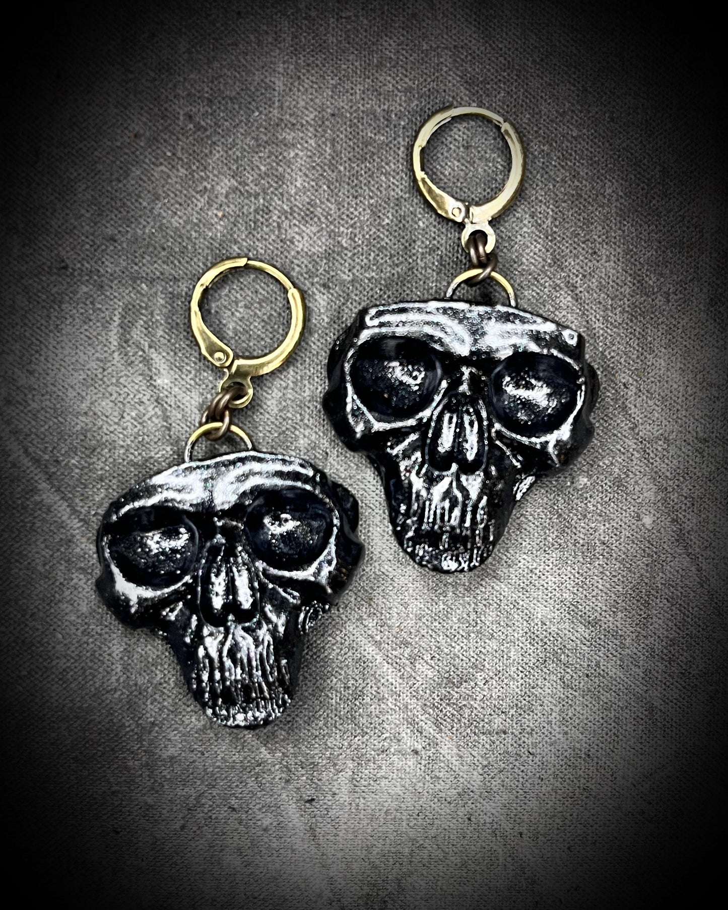 Sculptural black skull earrings on hypoallergenic brass hooks — gothic handmade statement earrings.