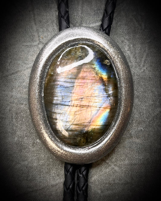 Stormy cool tone flashy labradorite crystal bolo tie in a gunmetal finish. Men's crystal jewelry trends and western inspired fashion 2026. 