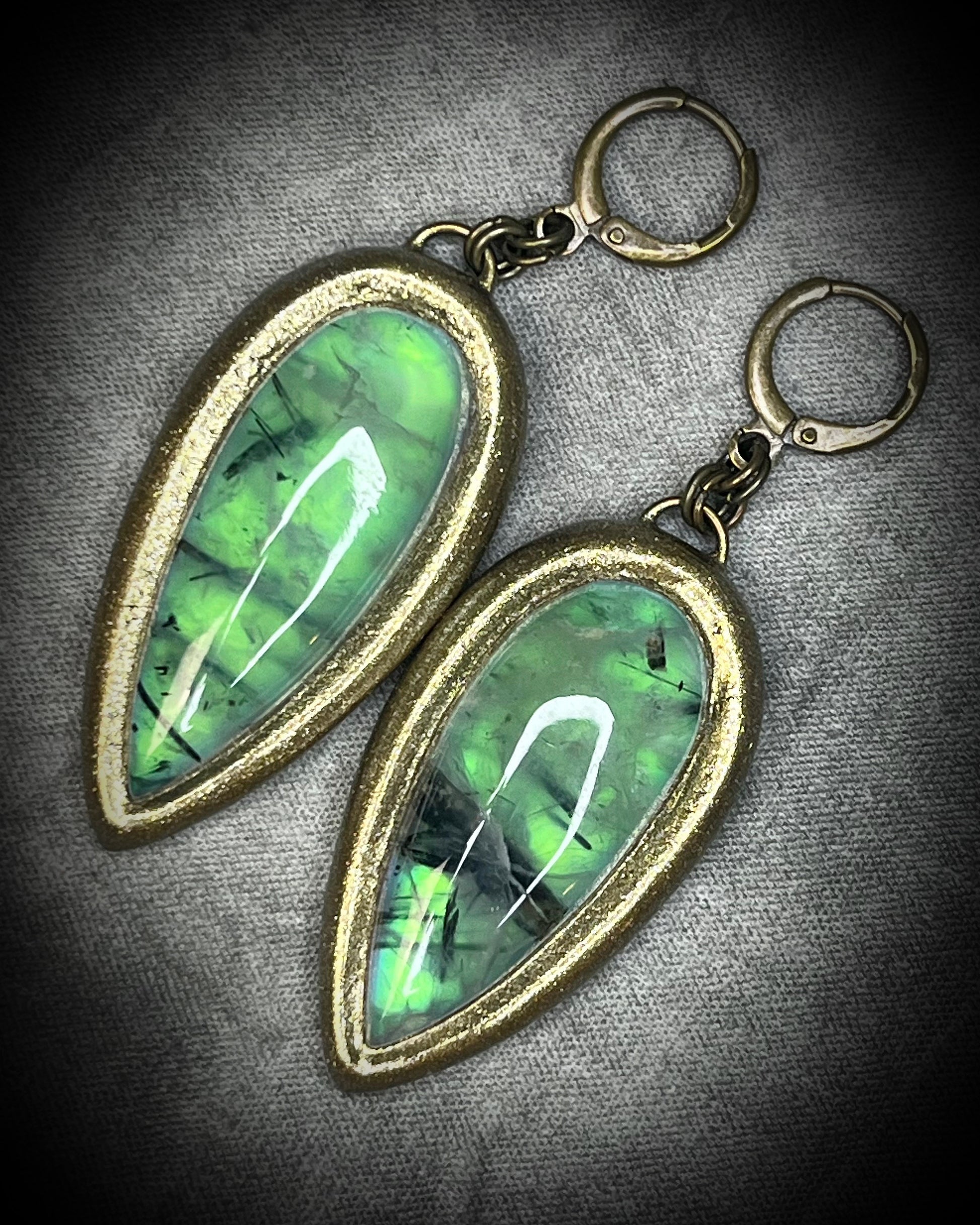 Teardrop-shaped prehnite crystal earrings with soft green color, gold finish, and hypoallergenic earring hooks, handmade by Become Spellbound.