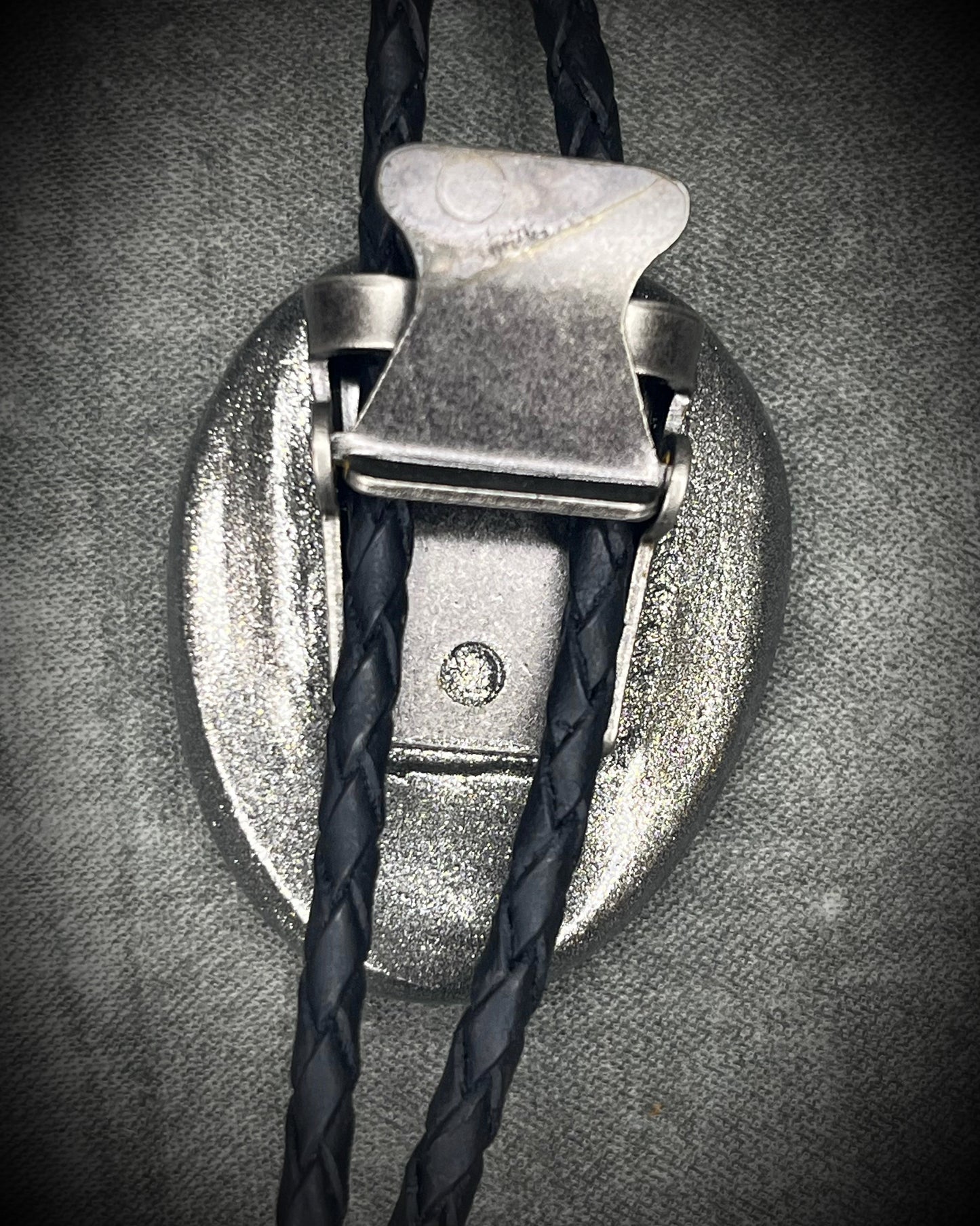 Trilobite fossil bolo tie with gunmetal finish, black leather, and dark silver bolo tips, handmade by Become Spellbound in Baltimore, Maryland.