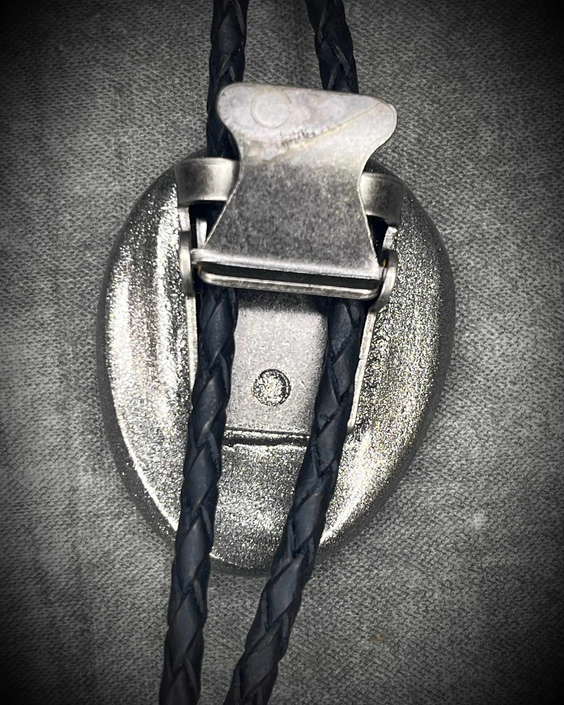 Trilobite fossil bolo tie with gunmetal finish, black leather, and dark silver bolo tips, handmade by Become Spellbound in Baltimore, Maryland.