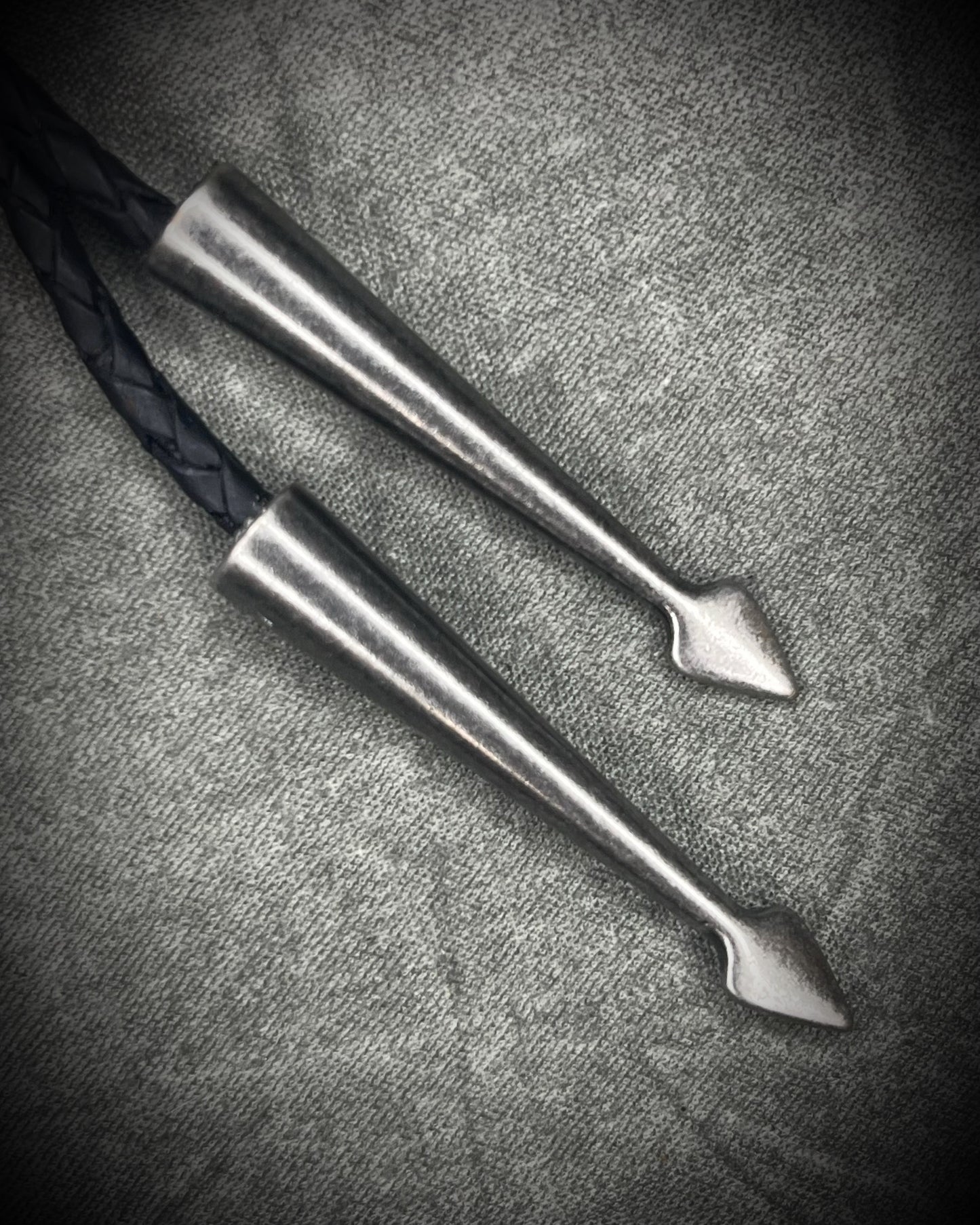 Trilobite fossil bolo tie with gunmetal finish, black leather, and dark silver bolo tips, handmade by Become Spellbound in Baltimore, Maryland.