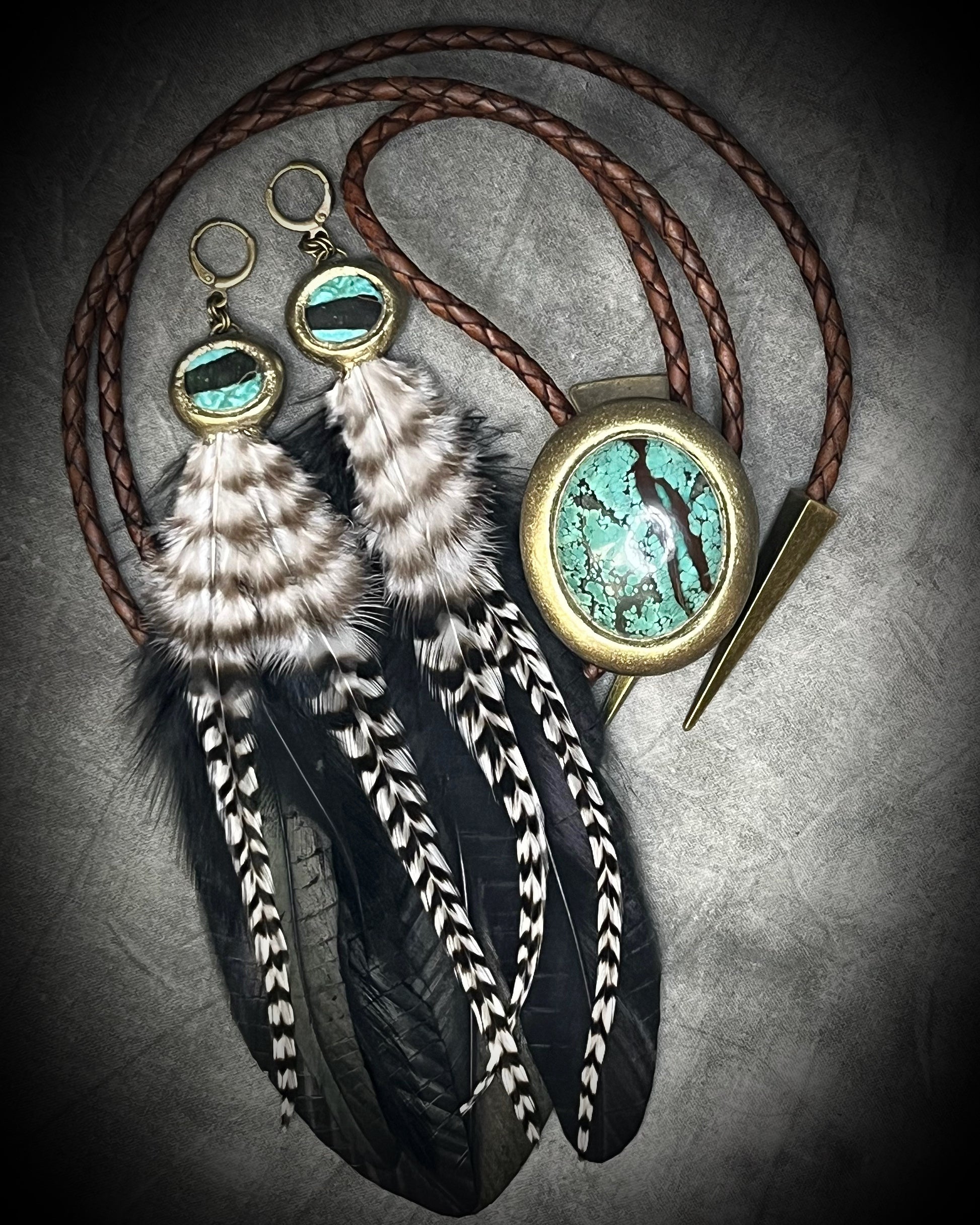 Turquoise and feather earrings with natural blue-green stone, gold finish, and hypoallergenic brass huggie hooks, handmade by Become Spellbound. Shown here with Bolo tie as a set. 
