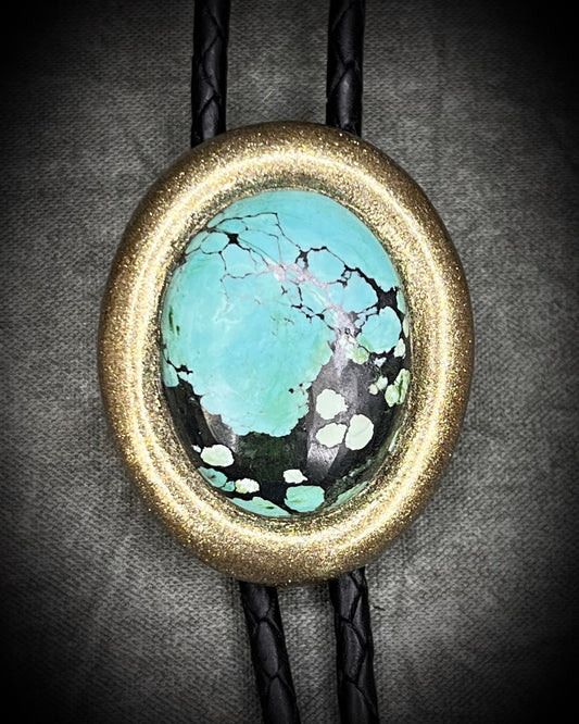 Turquoise bolo tie necklace in gold finish on black leather, artisan Western statement jewelry with crystal focal stone, handmade in Baltimore Maryland.