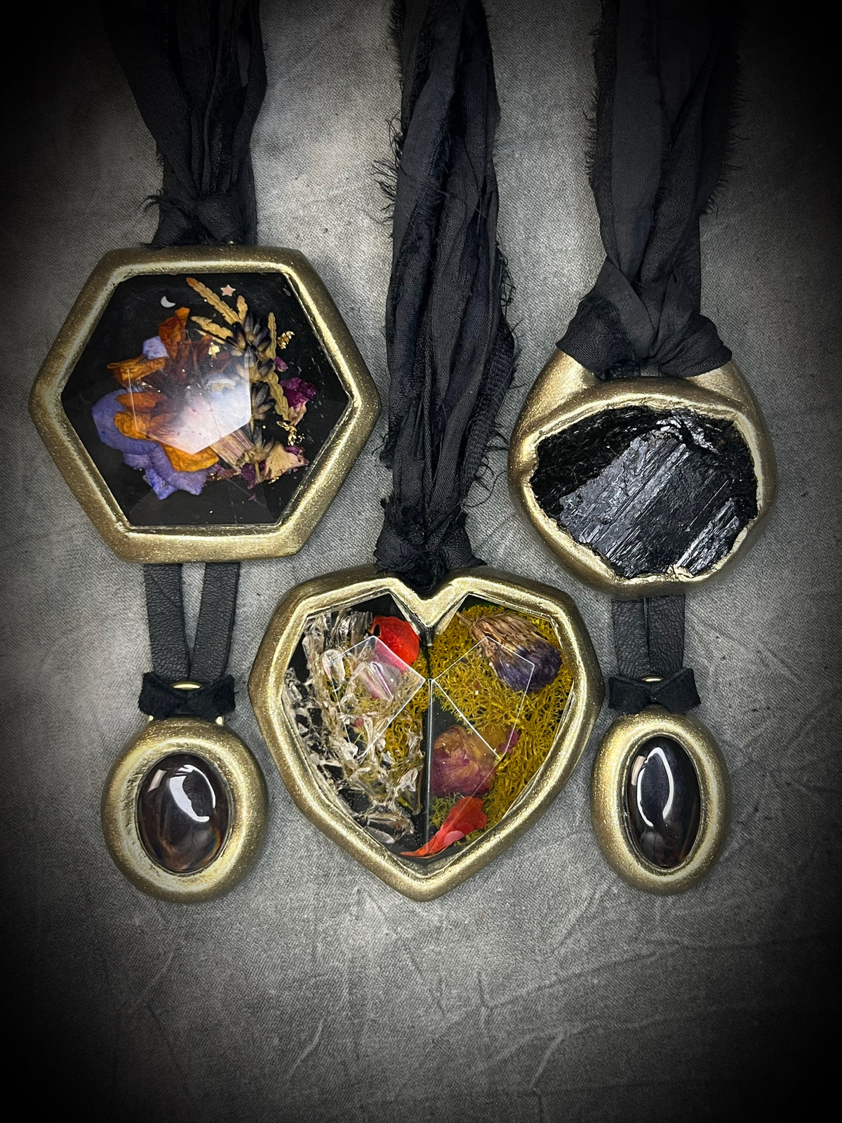 Various fall protection talismans including: Raw black tourmaline chunk protection talisman with gold finish on black recycled silk, handmade by Become Spellbound in Baltimore, Maryland.