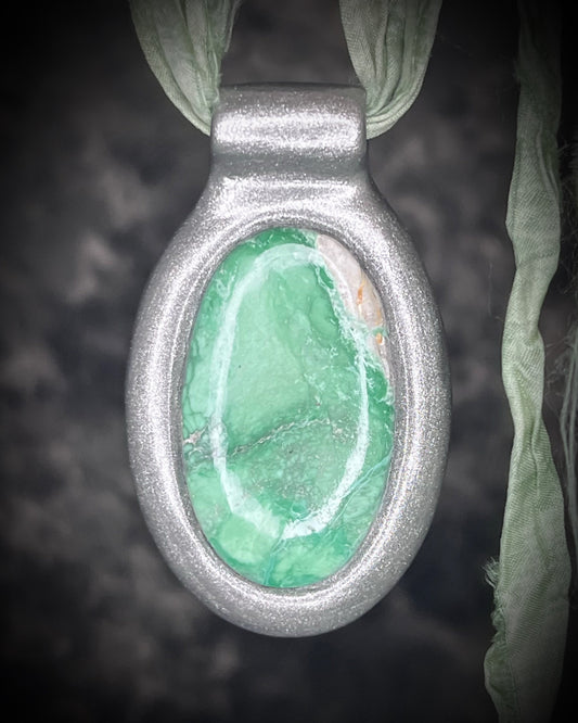 Variscite crystal talisman in a sculptural silver-finish setting on sea green recycled silk cords, a one-of-a-kind heart chakra-inspired necklace handmade by Become Spellbound in Baltimore, Maryland.