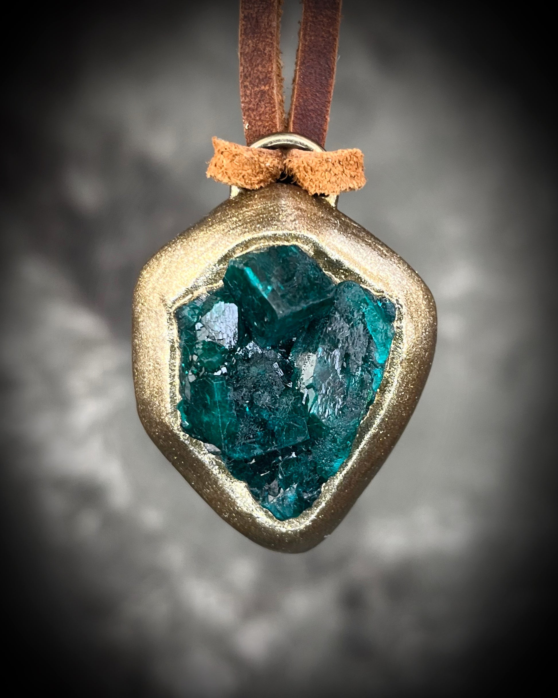 Vivid emerald green chunky dioptase crystal pendant handmade and set in a gold finish, hung from soft brown leather for an earthy, unisex vibe. Jewery for men or gift for her. Heart chakra jewelry.