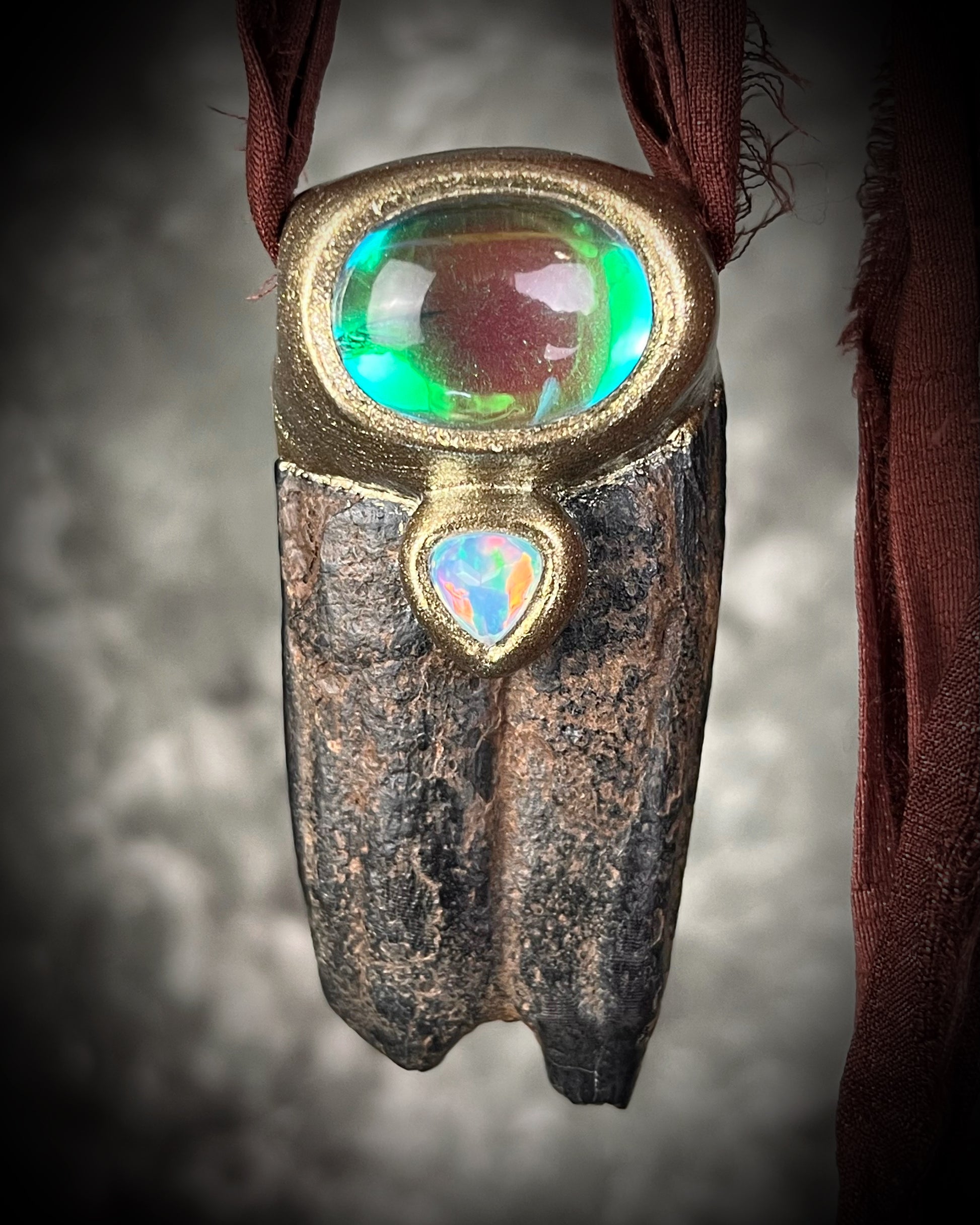 Western Style 'Year of the Horse 2026' inspired horse tooth fossil necklace with glowing green fluorite crystal and fiery opal gemstone. Gold finish horse necklace with brown recycled silk for an earthy and grounded talisman for her.