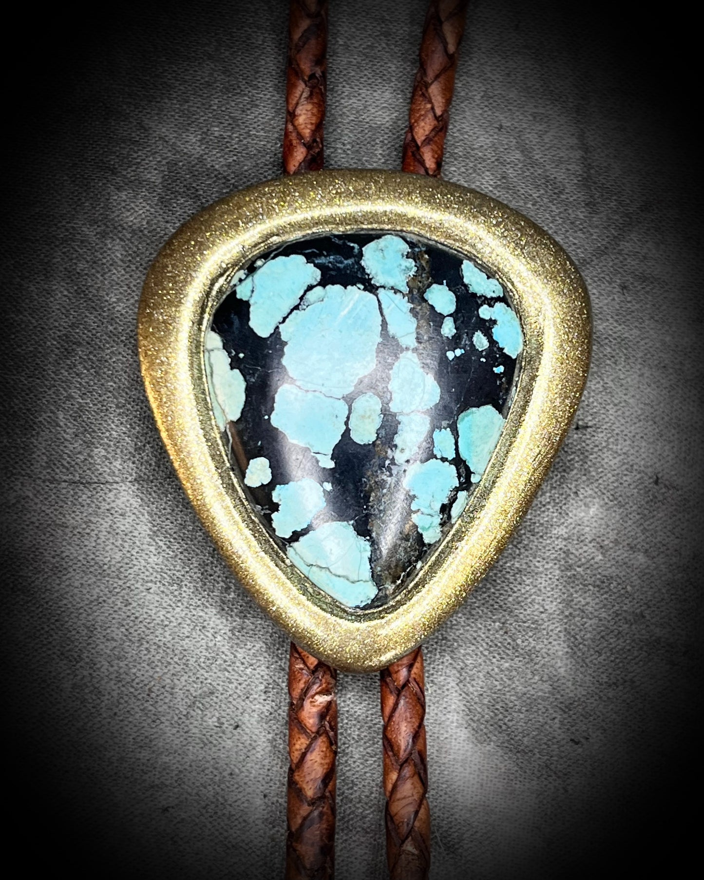 Western fashion trend 2025 handmade turquoise bolo tie in a gold finish on brown leather. Best holiday gift for him.