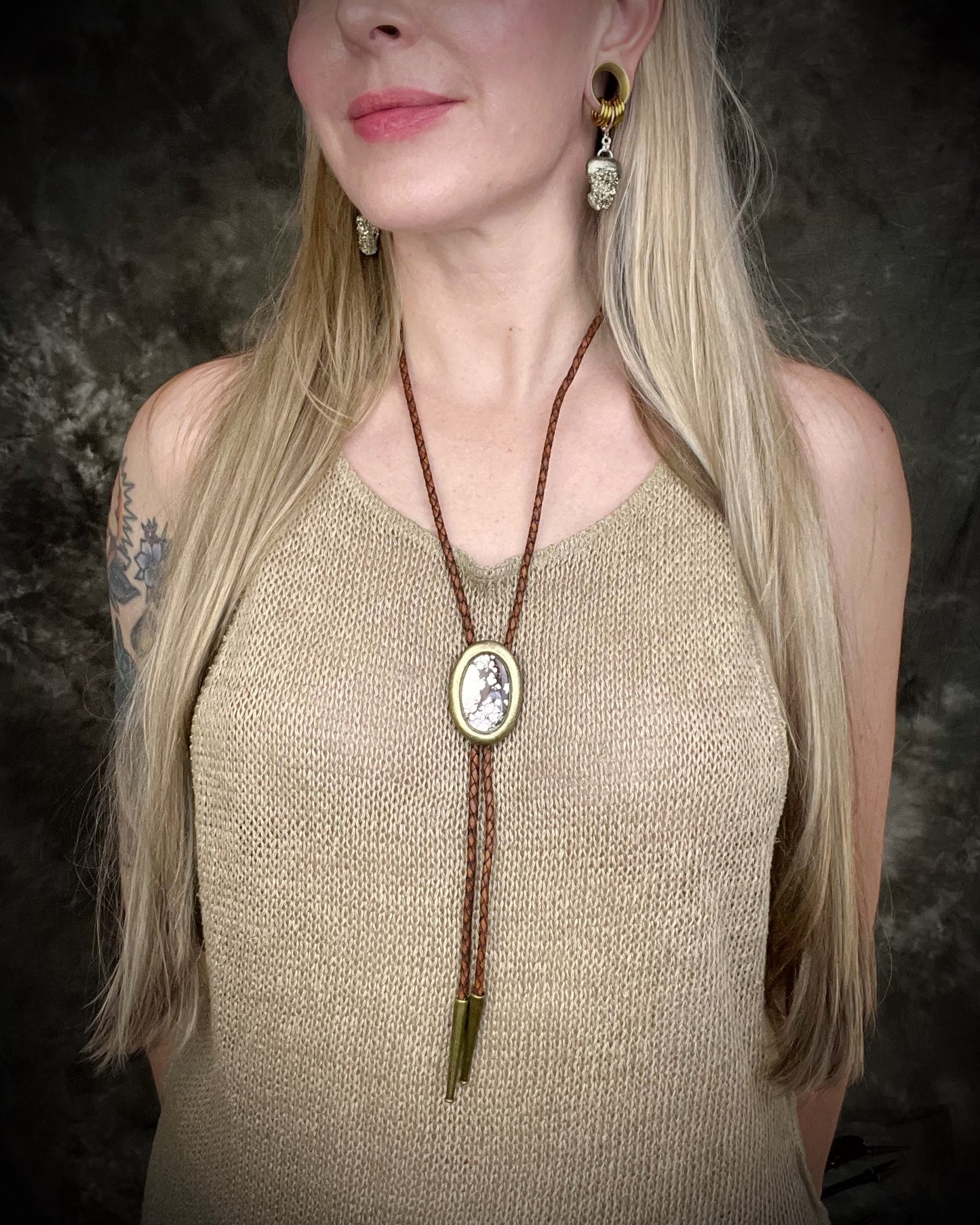 Wild Horse magnesite bolo tie with gold finish on brown leather cord, earthy Western statement jewelry featuring natural patterned stone, handmade bolo tie necklace Baltimore Maryland