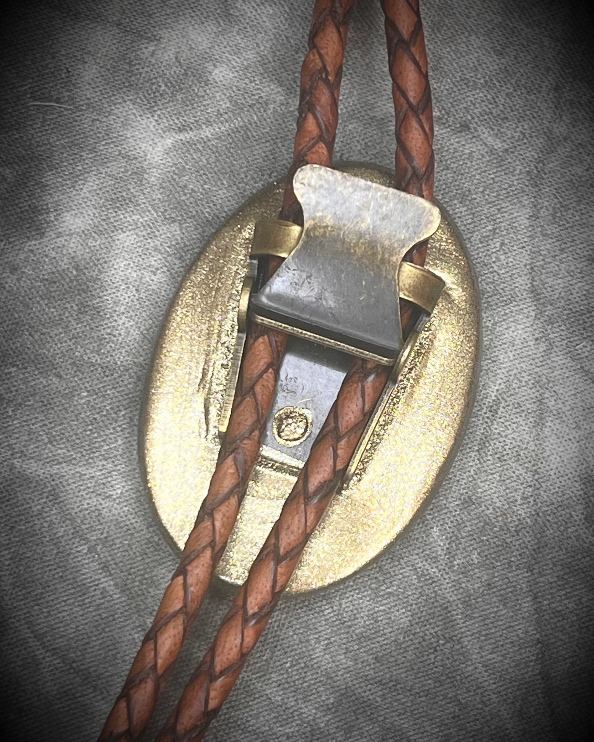 Wild Horse magnesite bolo tie with gold finish on brown leather cord, earthy Western statement jewelry featuring natural patterned stone, handmade bolo tie necklace Baltimore Maryland