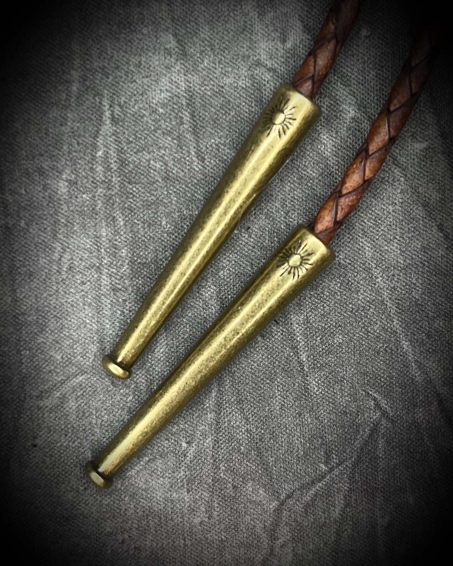 Wild Horse magnesite bolo tie with natural cream and brown markings, brown leather, gold finish, and gold bolo  starburst tips.