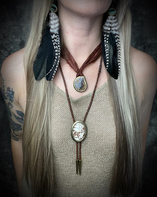 Wild Horse magnesite bolo tie with natural cream and brown markings, brown leather, gold finish, and gold bolo tips.