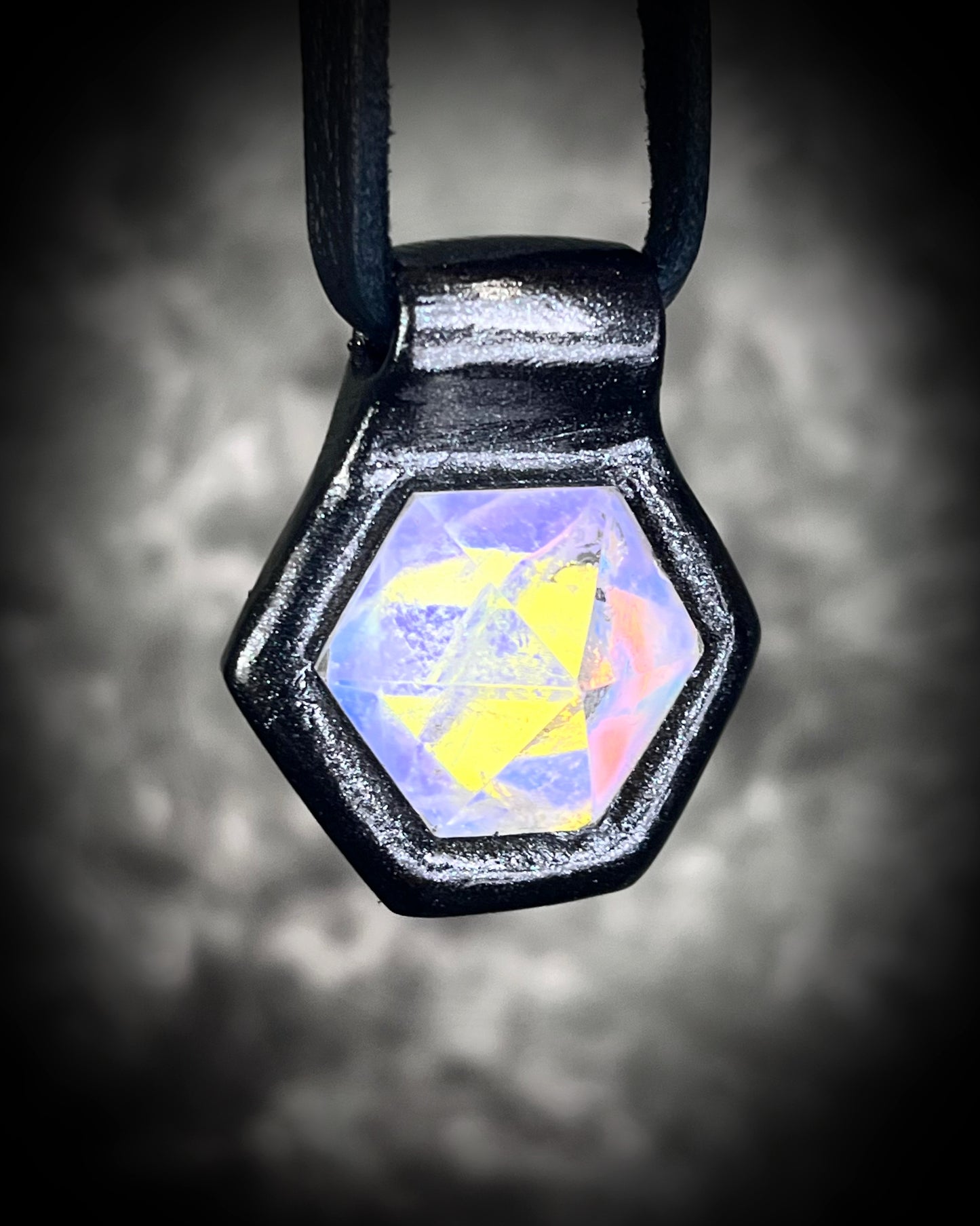 Witchy opalescent quartz crystal pendant framed in black, spiritual necklace on leather cord, gothic statement jewelry for Halloween and mystical style.