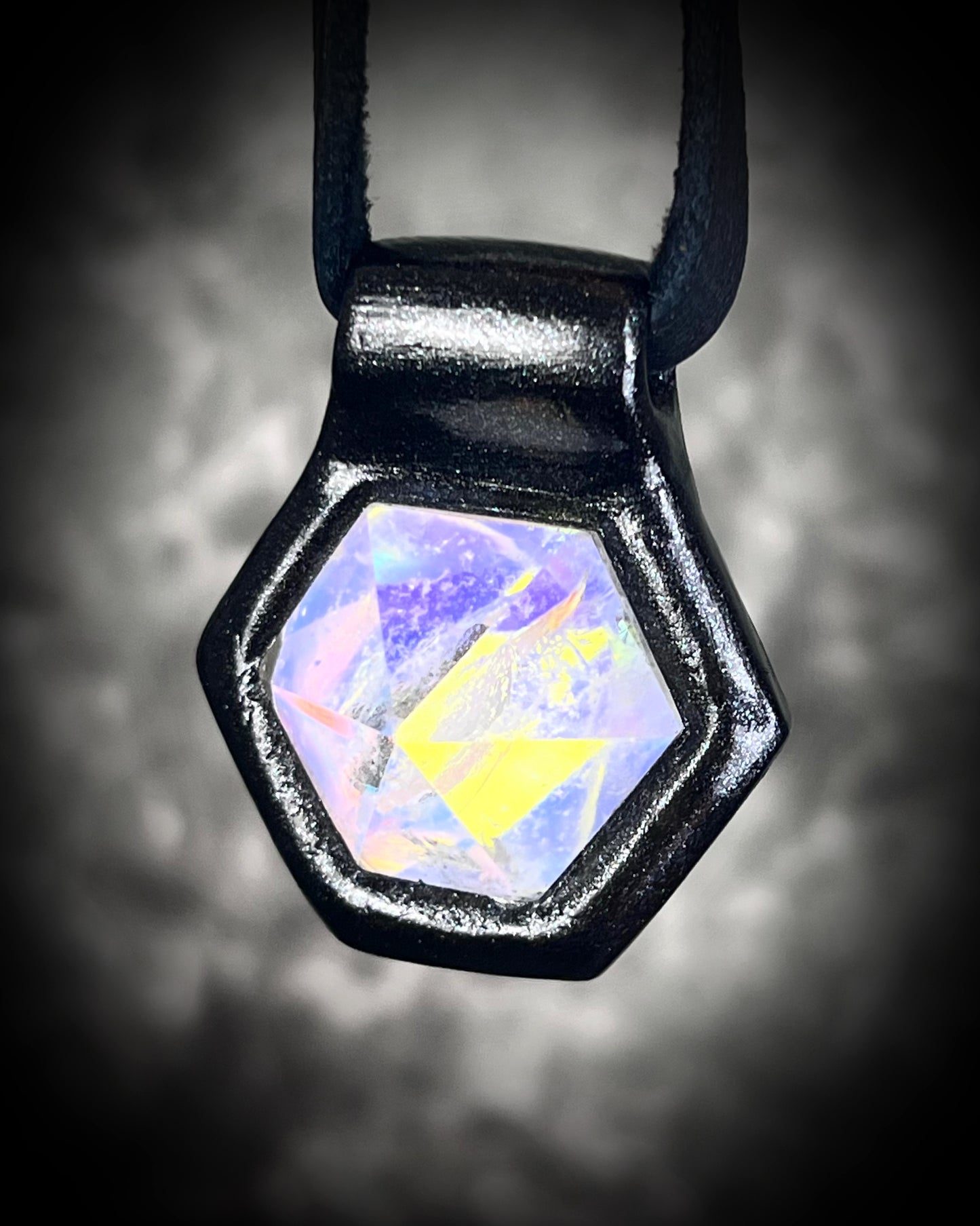 Witchy opalescent quartz crystal pendant framed in black, spiritual necklace on leather cord, gothic statement jewelry for Halloween and mystical style.