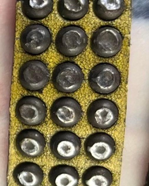 closeup of distressed marigold leather studded bracelet. 