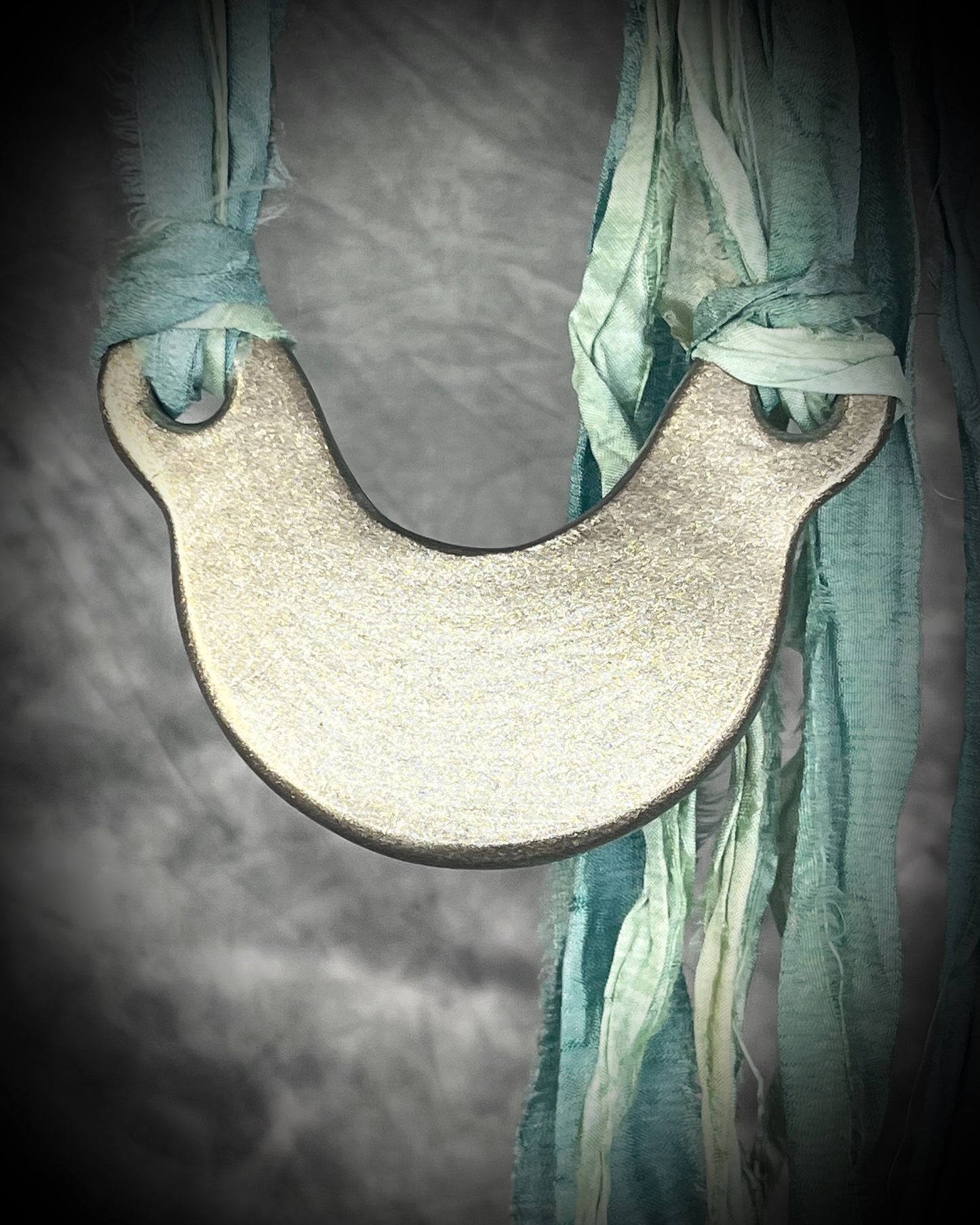 Handmade designer opalescent quartz gemstone crescent moon pendant in a gold finish.  This crystal healing necklace is strung from mint green recycled silk for the eco-friendly jewelry collector.  