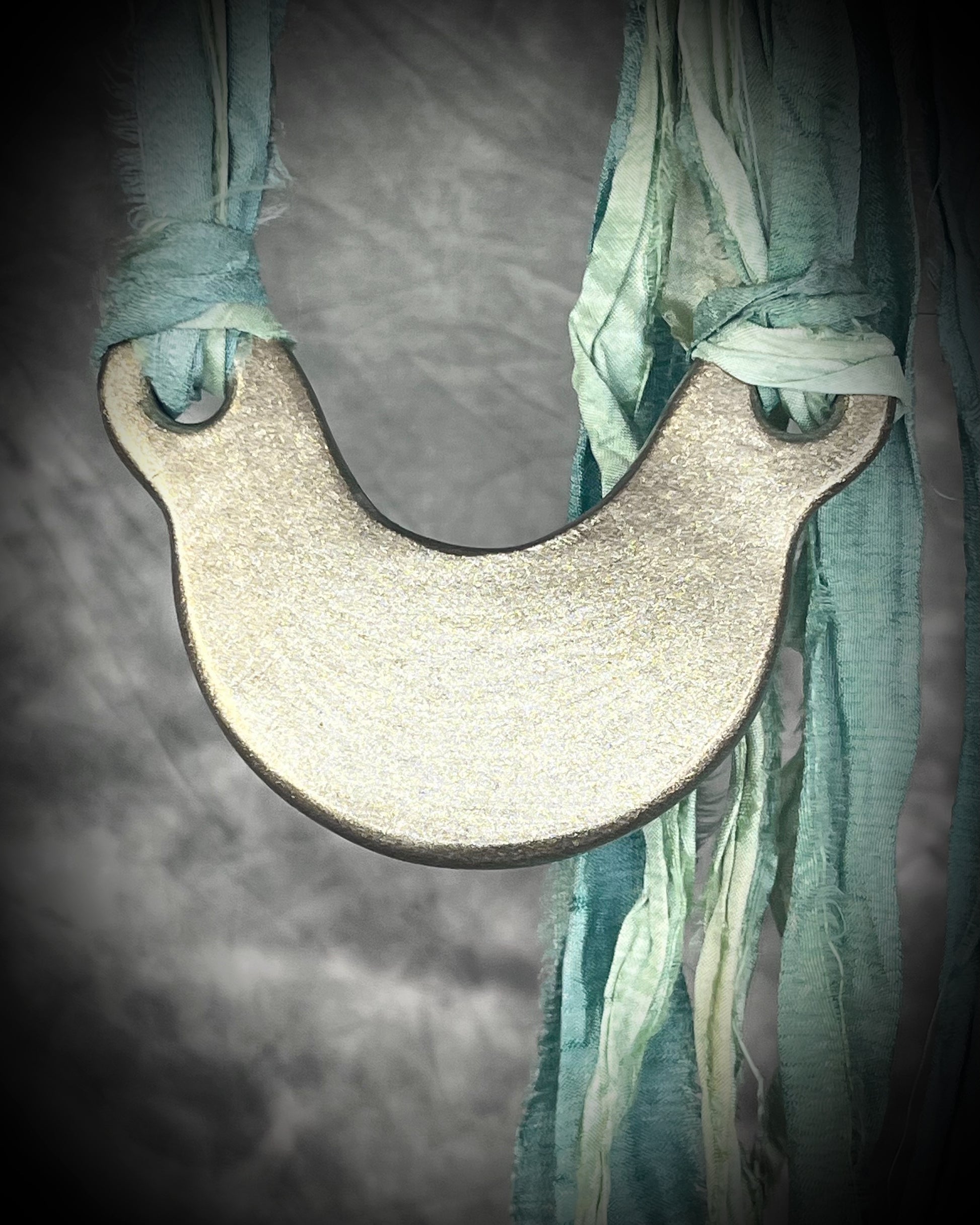 Handmade designer opalescent quartz gemstone crescent moon pendant in a gold finish.  This crystal healing necklace is strung from mint green recycled silk for the eco-friendly jewelry collector.  