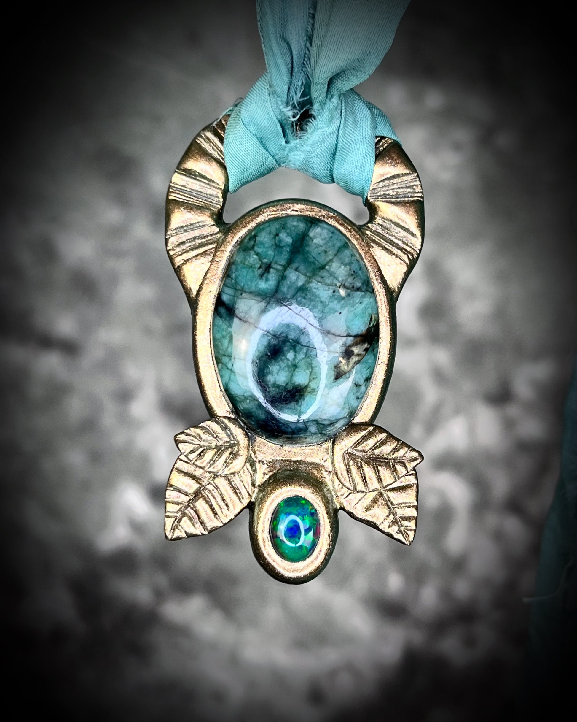 Emerald and black opal gemstone necklace in a luxe gold setting, crafted on aqua recycled silk. One-of-a-kind crystal healing pendant, sustainable and perfect for 2025 gifting. 