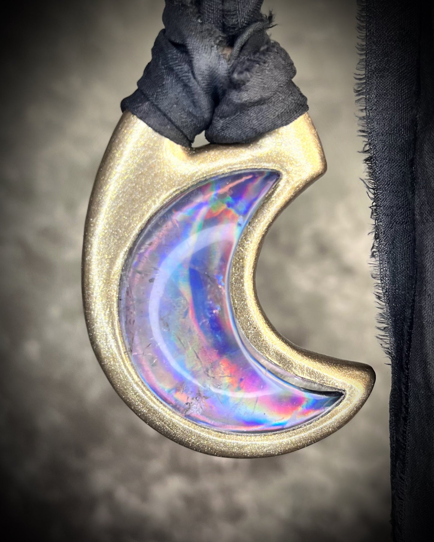 Metallic gold crescent moon pendant with iridescent rainbow quartz crystal on black recycled silk