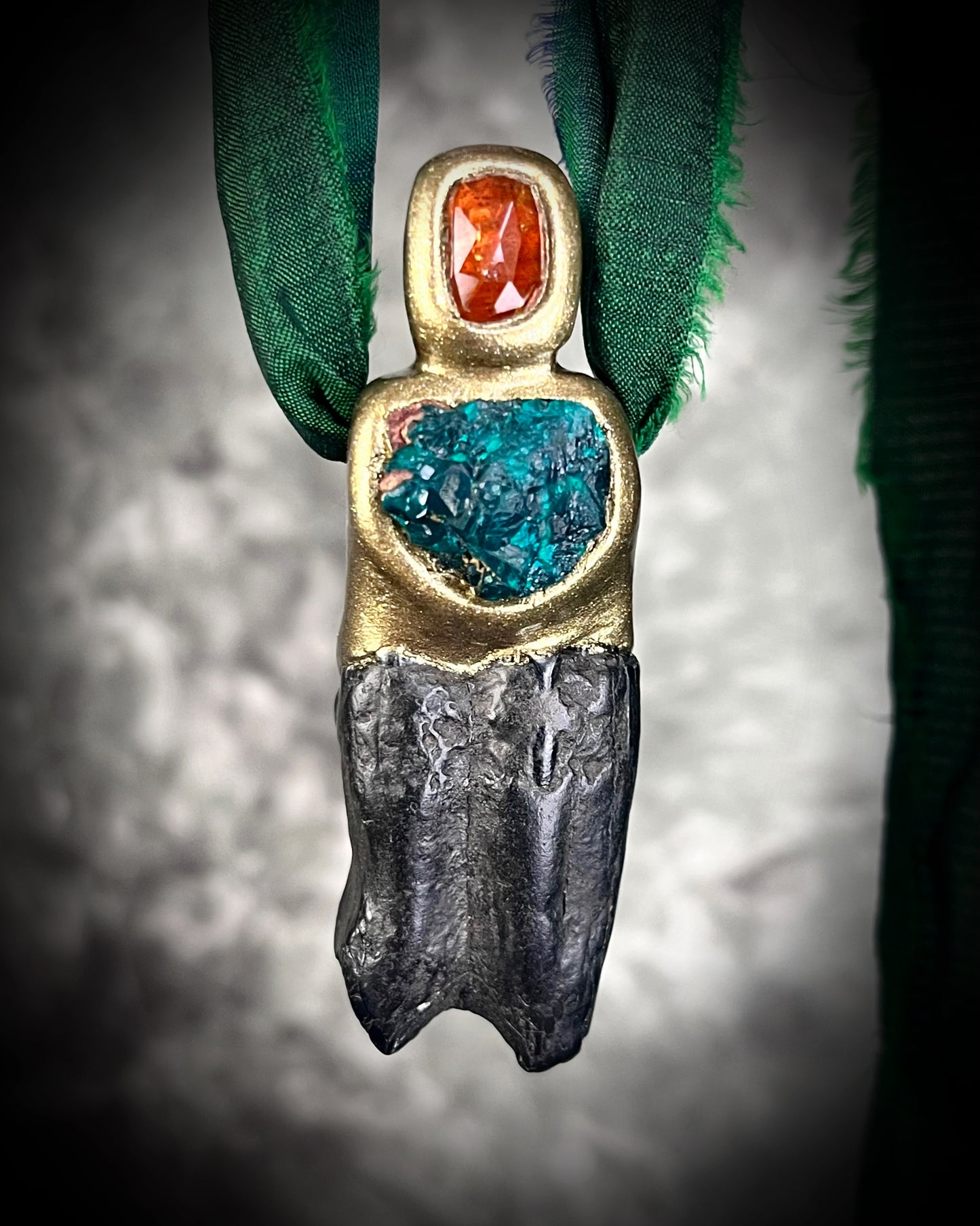 Equus horse tooth fossil talisman necklace with orange kyanite and green dioptase crystals in a gold-tone setting, hung on green recycled silk — handmade statement fossil jewelry.
