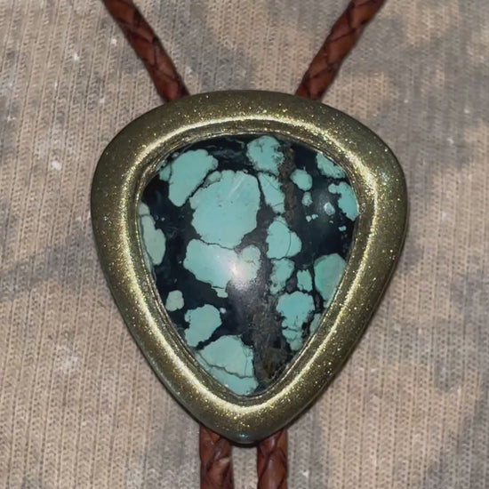 Mystical western wear turquoise bolo tie gift for him or her. Gold and brown leather with teal and black natural gemstone. 