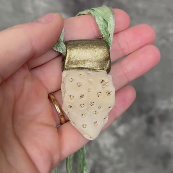 Genuine fossil coral set in a gold setting and hung from sea green recycled silks as a beachy oceanic summer jewelry look. Necklace handmade in Baltimore with coral from Calvert Cliffs.