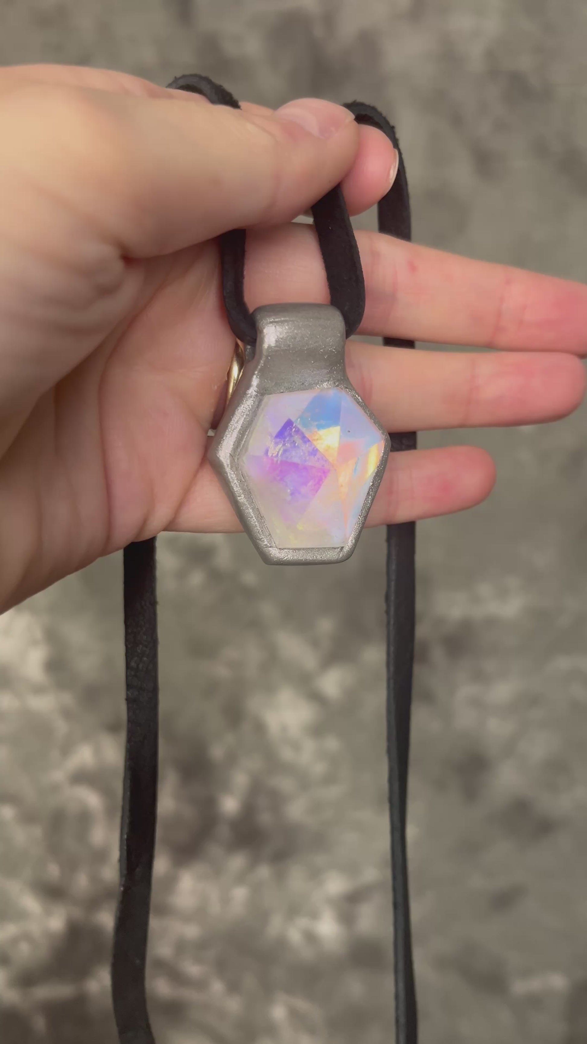 Handmade clear quartz crystal necklace with an opalescent flash that feels enchanted from another realm. Framed in silver in a hexagon shape and hung from black leather, this pendant feels cinematic, and like an unearthed treasure. 