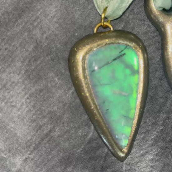 Handmade designer opalescent quartz gemstone crescent moon pendant in a gold finish.  This crystal healing necklace is strung from mint green recycled silk for the eco-friendly jewelry collector.  