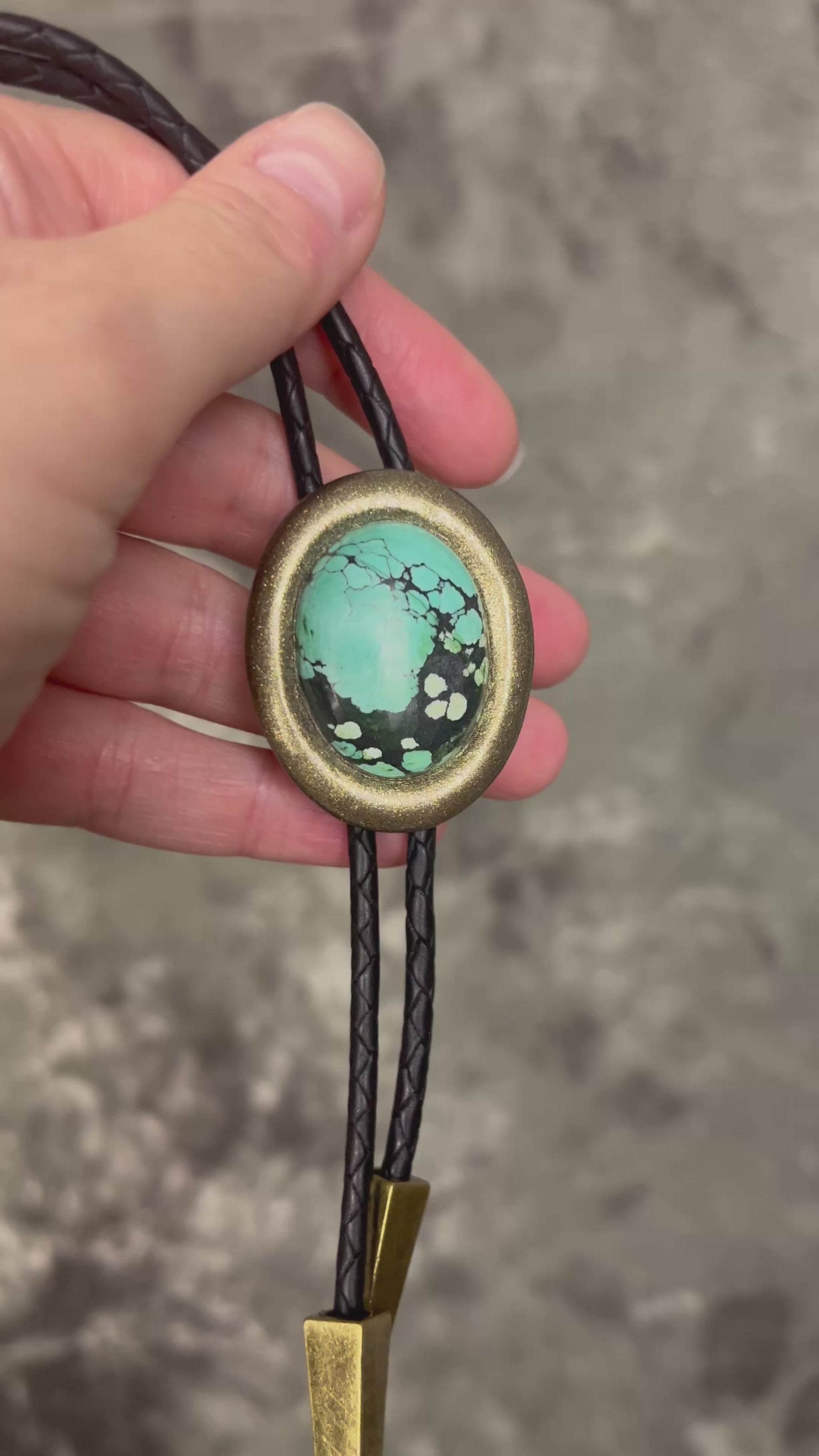 Turquoise bolo tie necklace in gold finish on black leather with spike tips, artisan Western statement jewelry with crystal focal stone, handmade in Baltimore Maryland.