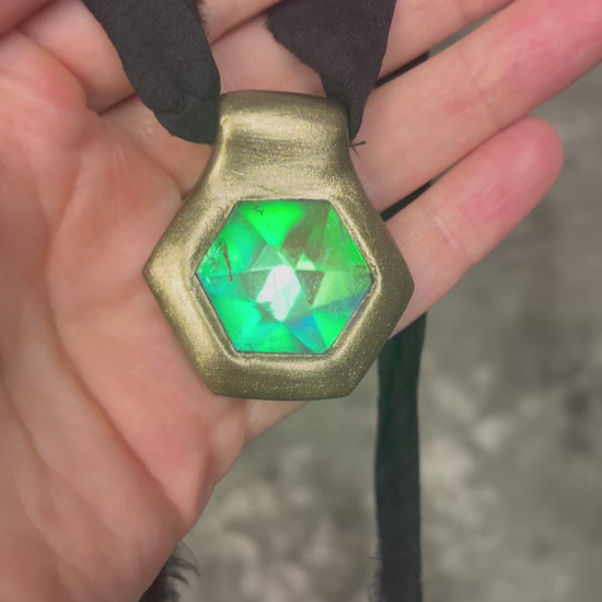 Handmade clear quartz crystal necklace with an aqua flash that feels oceanic and beachy. Framed in gold in a hexagon shape and hung from black recycled silk, this pendant feels like an unearthed treasure. Summer jewelry at its finest!