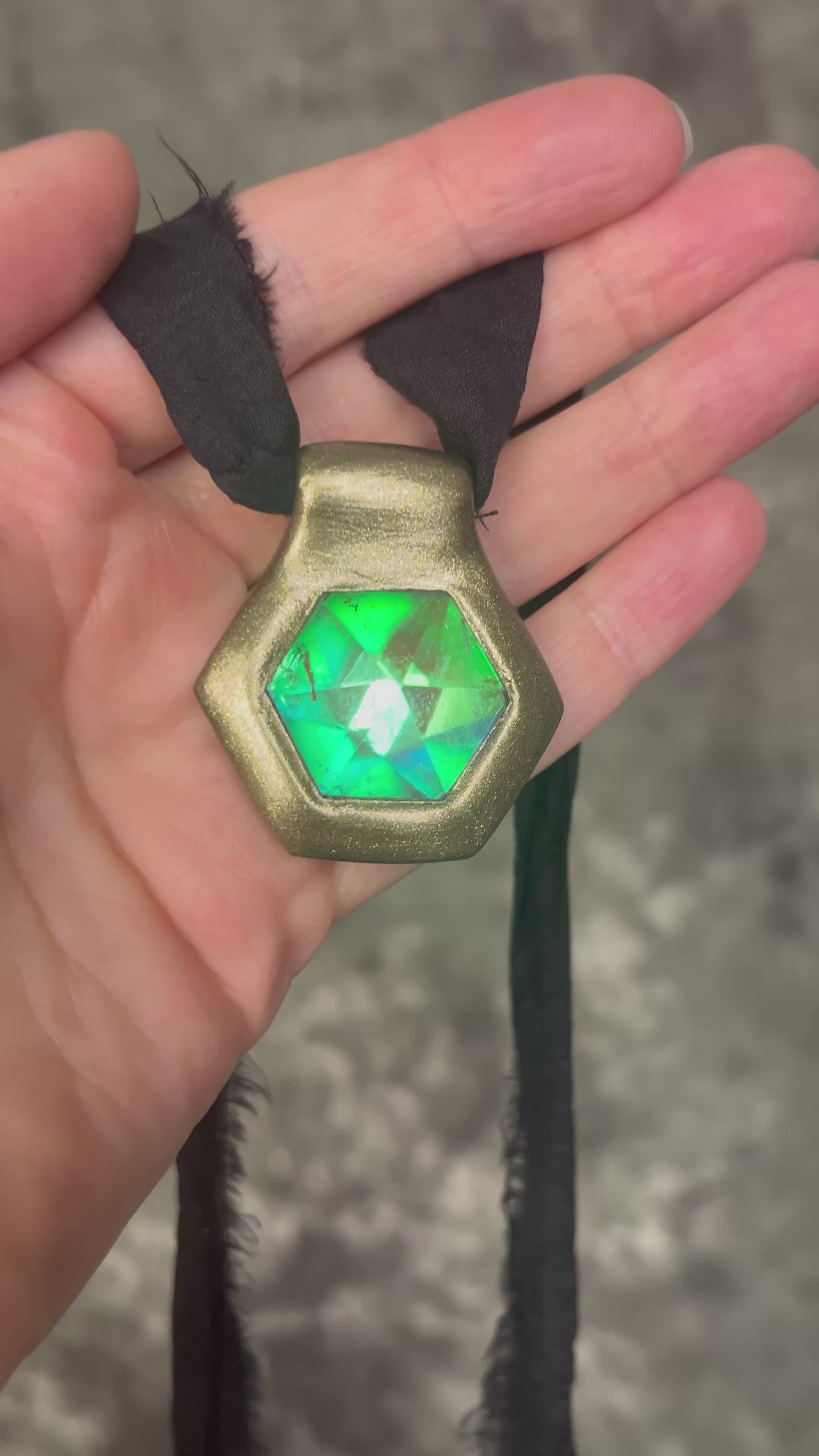 Handmade clear quartz crystal necklace with an aqua flash that feels oceanic and beachy. Framed in gold in a hexagon shape and hung from black recycled silk, this pendant feels like an unearthed treasure. Summer jewelry at its finest!