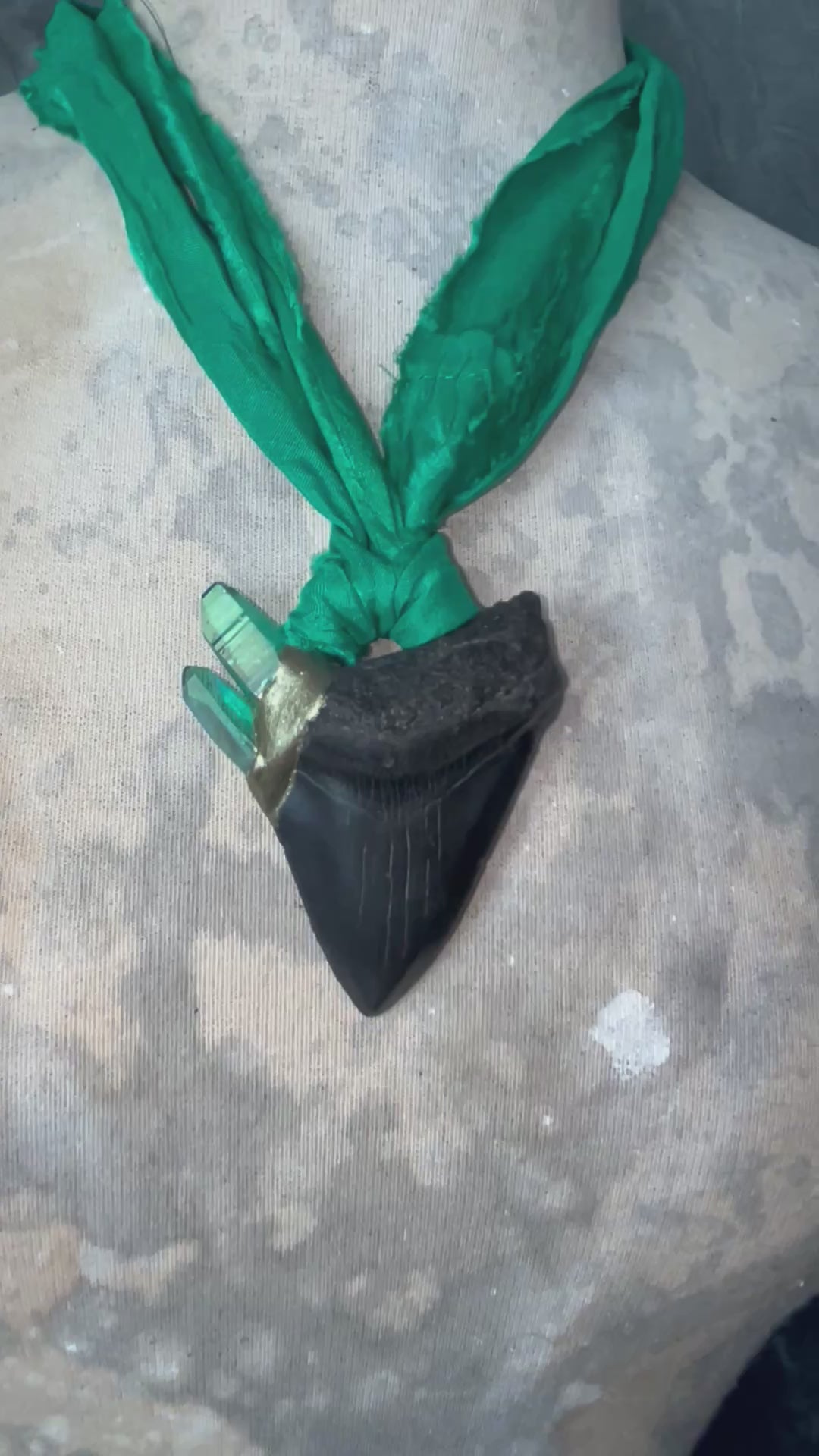 Video of Ancient megalodon fossil tooth necklace with green aura quartz points, hung from sustainable green recycled silk. Gemstone fantasy jewelry for the wild-hearted and fearless. Handmade jewelry gift for her holiday 2025.