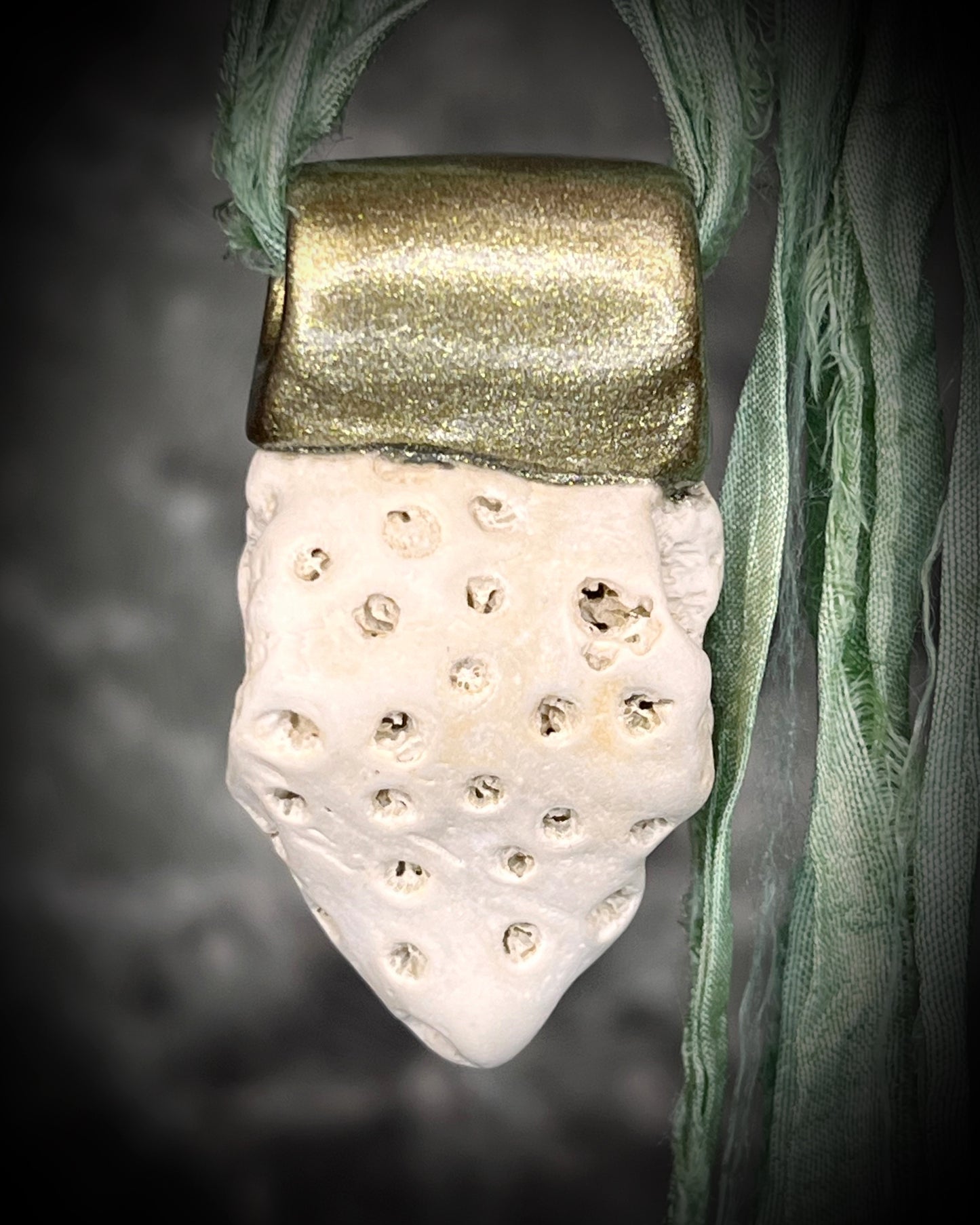 Genuine fossil coral set in a gold setting and hung from sea green recycled silks as a beachy oceanic summer jewelry look. Necklace handmade in Baltimore with coral from Calvert Cliffs.