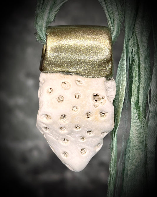 Genuine fossil coral set in a gold setting and hung from sea green recycled silks as a beachy oceanic summer jewelry look. Necklace handmade in Baltimore with coral from Calvert Cliffs.